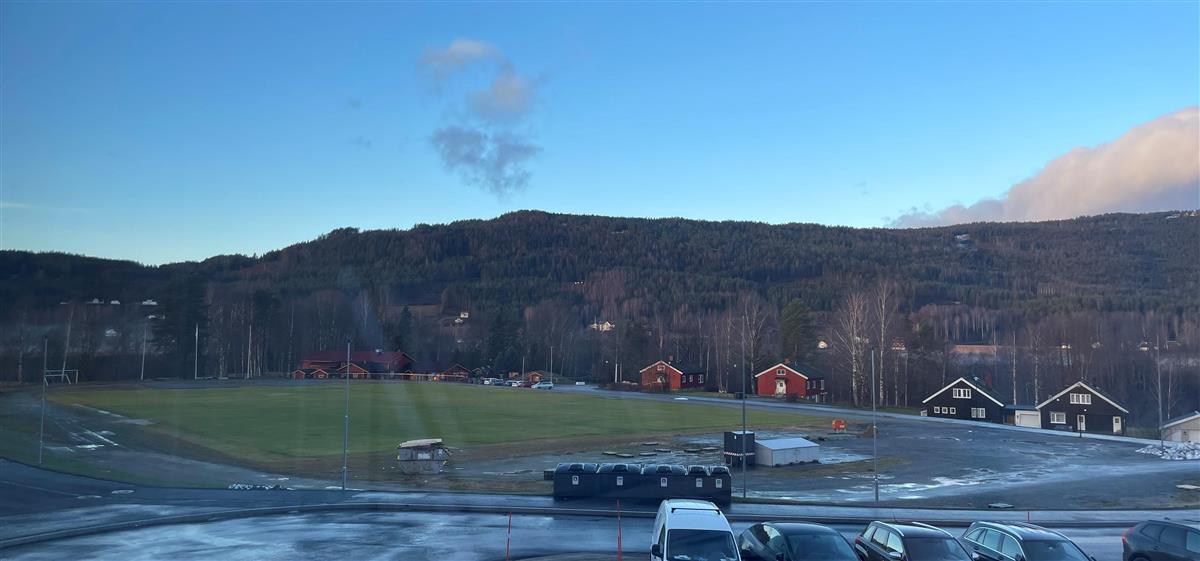 Oversiktsbilde av gressbane og friidrettsbane, blå himmel - Klikk for stort bilde