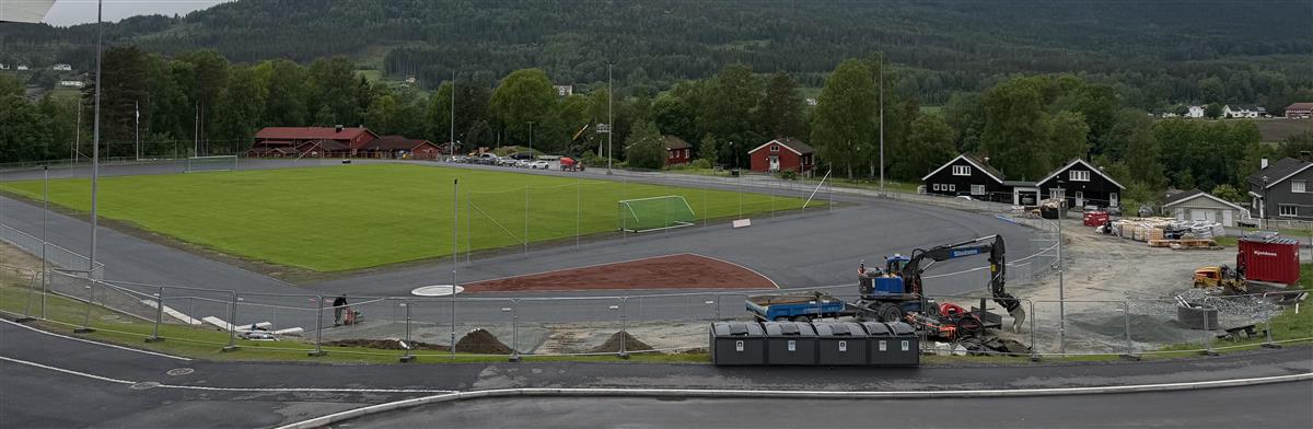 Fotballbane, overskyet, asfaltbane rundt fotballbanen, anleggsmaskiner - Klikk for stort bilde